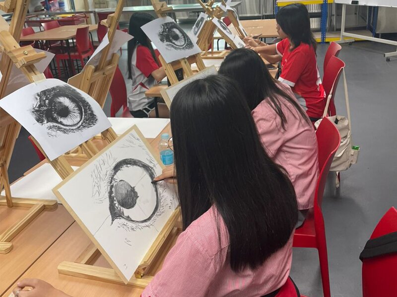 Secondary students learning how to draw in detail the eye of a bird during their Fine Art CCA activity