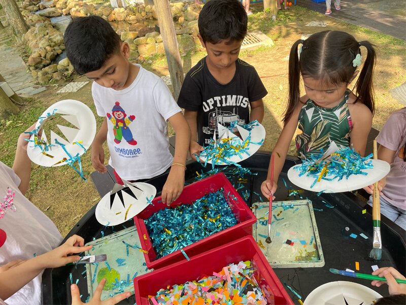 Secondary School students playing with congkak during the Malaysia Month celebration