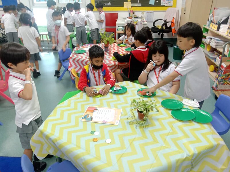 Early Years students learning about colours through paint