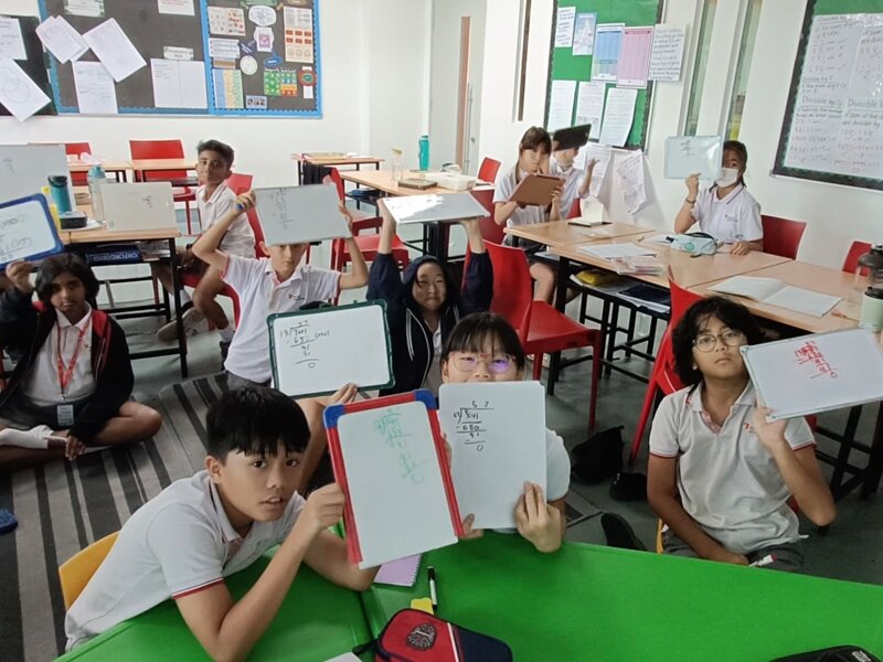 Primary School students showing off their maths calculation on their white board