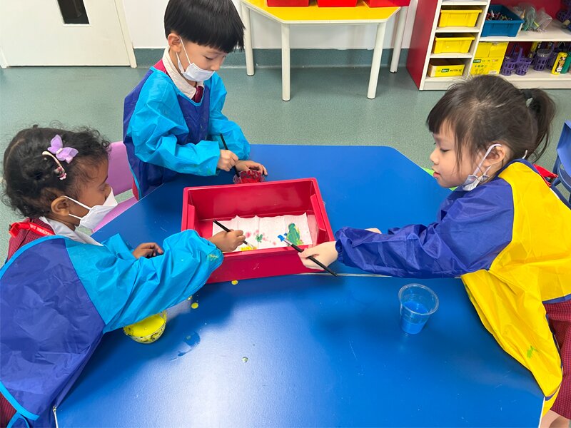 Early Years students learning about colours through paint