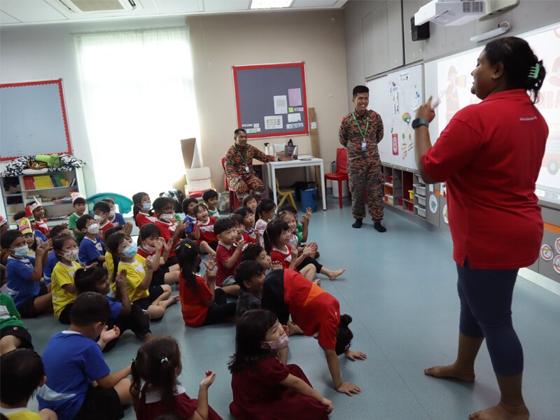 Early Years receiving briefing on what to do when there is a fire from the Bomba