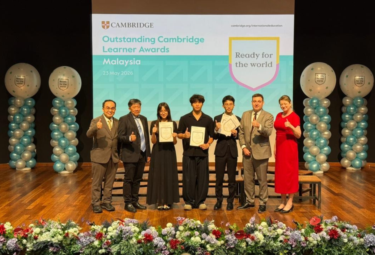 Award recipients Vianne, Benjamin, and Eliam holding their Cambridge certificates alongside Cambridge Country Director Mr Ng Kim Huat during the Outstanding Cambridge Learner Awards ceremony.