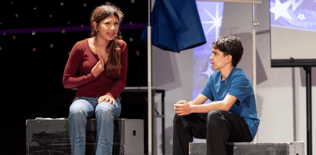 Two students acting on stage during a drama performance at IU Night 2026.