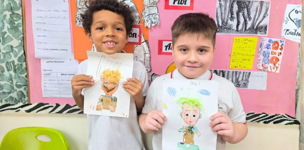 Two TISKL Primary students holding their artwork during a Diversity Week art activity.